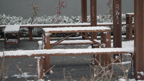 wooden tables and benches covered in snow