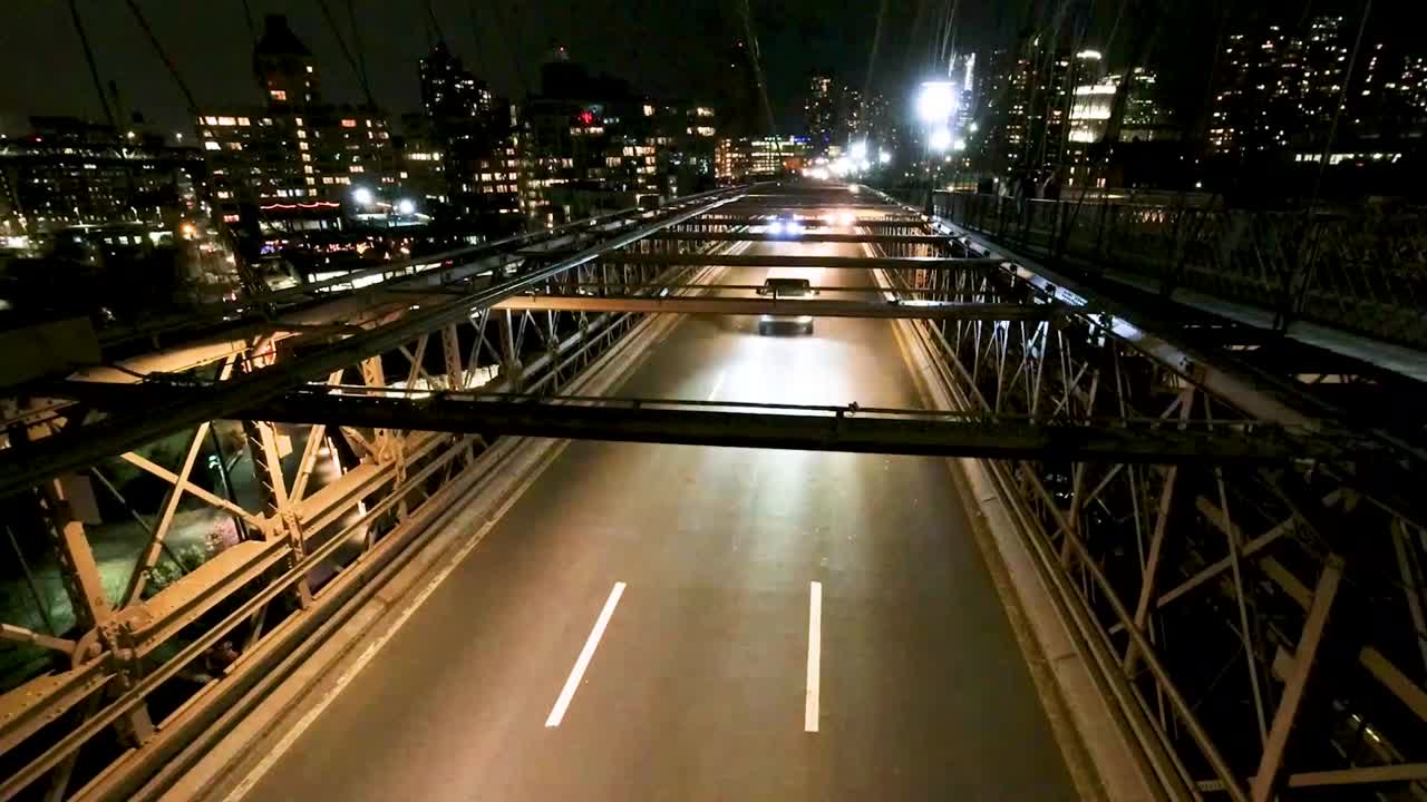 뉴욕 시의 브루클린 다리에서 밤에 운전하는 자동차의 타임스