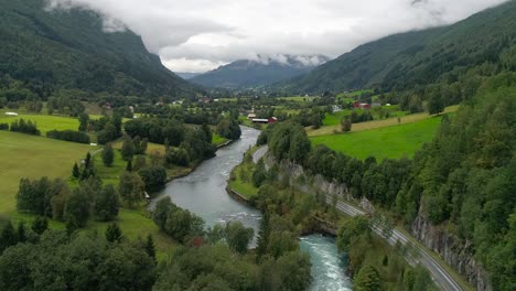 aerial forward dolly shot of car driving through the cliffs and beautiful landscaping of the svortesvada fjord and river in stryn