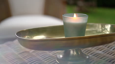 Primer-Plano-De-Una-Vela-Encendida-En-Una-Mesa-Con-Asientos-Al-Aire-Libre-En-Un-Bar,-Hotel,-Boda-O-Restaurante-Elegante