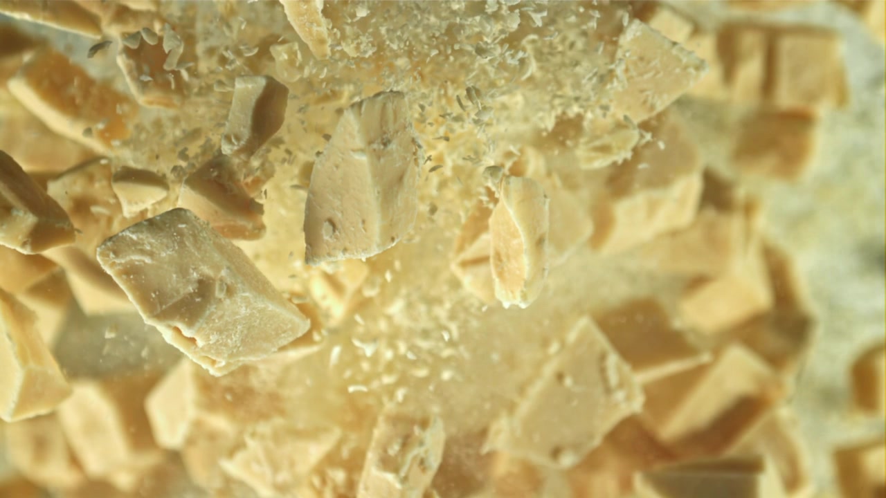 Lækre hvide chokoladestykker, der falder i slowmotion