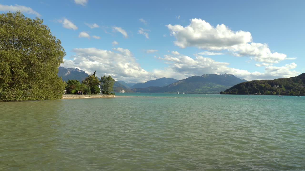 vista panorámica del lago annecy y sus montañas con un cielo azul y algunas nubes