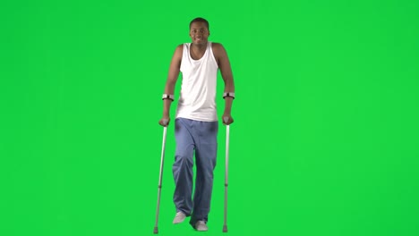 ethnic young man walking with crutches footage