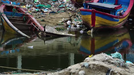 Barcos-Coloridos-De-Madera-Naufragan-Abandonados-En-Una-Zona-Contaminada-Con-Montones-De-Basura