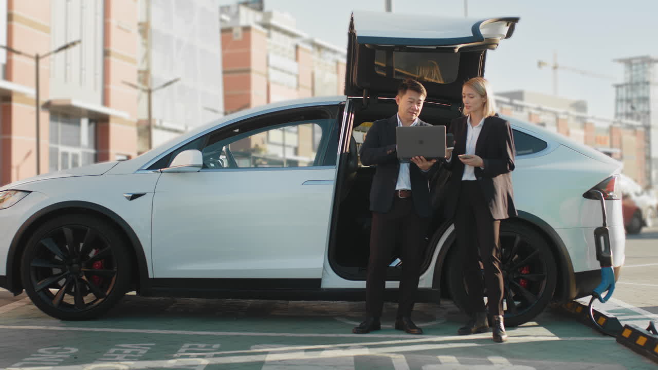 사업가 들 은 전기 차량 충전소 근처 의 프로젝트 에 대해 논의 한다