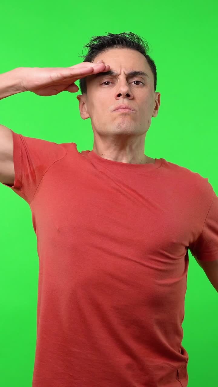Man in red shirt saluting on green screen