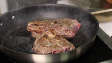 lamb chops frying in a pan