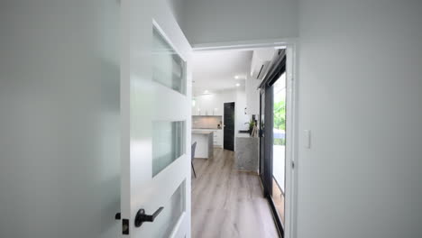 modern open plan kitchen dining living room at the end of a light-filled hall way