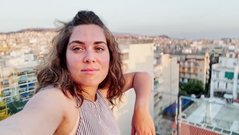woman admiring city view from rooftop at sunset, athens, greece.