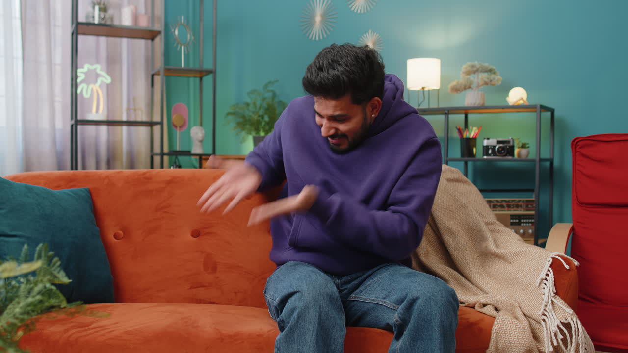 Indian man raising hands asking what why reason of failure disbelief irritation by troubles at home