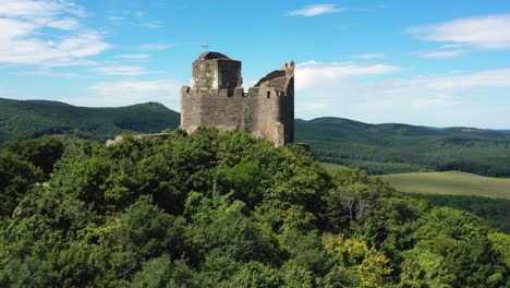 Imágenes-De-Drones-Sobre-Las-Ruinas-De-Un-Antiguo-Castillo-De-La-Edad-Media-En-Holloko,-Hungría-Drone-Vuela-Hacia-Atrás-Y-Sobre-El-Castillo