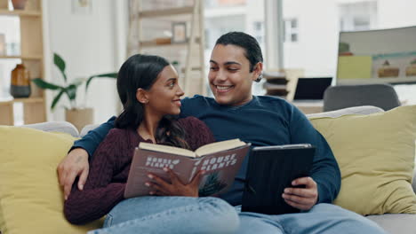 couple, reading a book and tablet on a home sofa