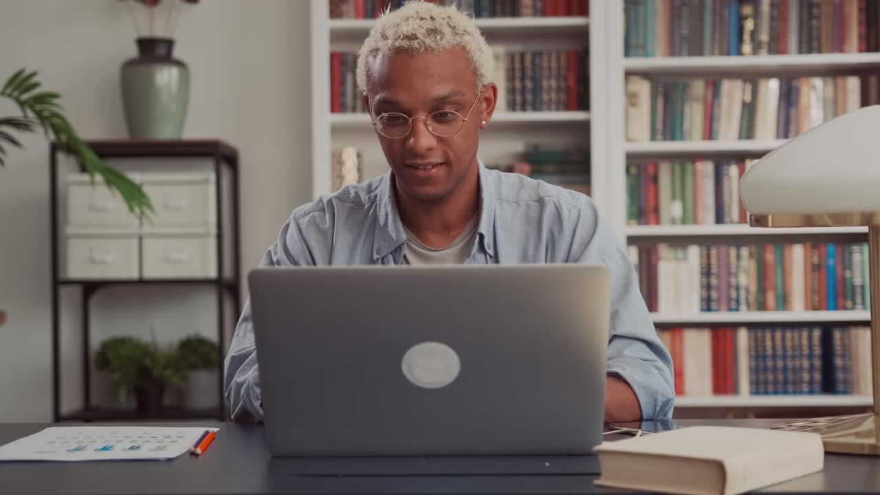 Close up of young african american businessman opening laptop and start working