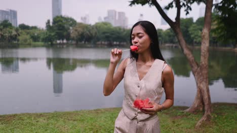 woman eating watermelon in a park