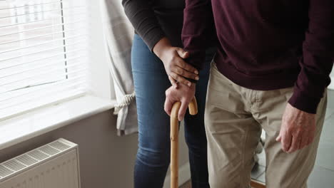 supporting an elderly person with a cane