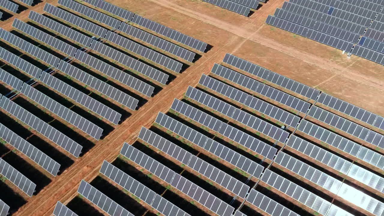 Sun hitting endless rows of solar panels, massive energy production
