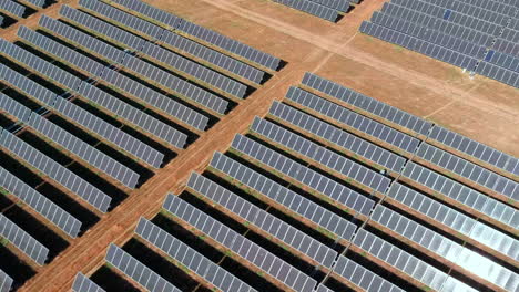 sun hitting endless rows of solar panels, massive energy production