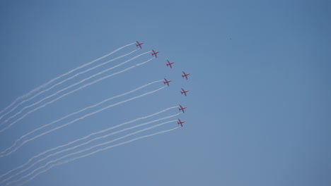 a formation of red jets creating smoke trails at the aero india air show by surya kiran aerobatic team