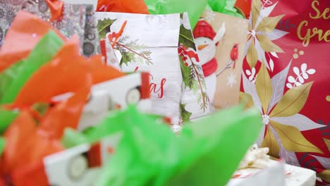 Slow-4k-Establishing-Shot-Pile-of-Festive-Personal-Care-Products-Colorful-Christmas-Gifts-Bags-Eve-Boxes-Greeting-Cards-Wrapped-in-Multicolor-Holiday-Paper-Secret-Santa