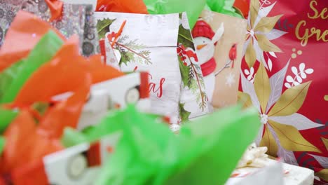4k estableciendo lentamente una pila de productos de cuidado personal festivos coloridos bolsas de regalos de navidad cajas de víspera tarjetas de felicitación envueltas en papel de vacaciones multicolor secreto de santa