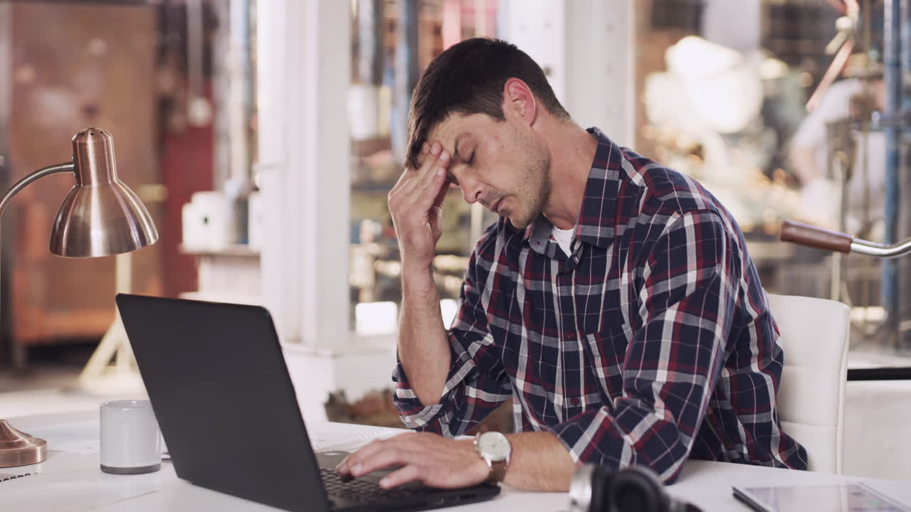 Man Working on a Laptop in a Workshop