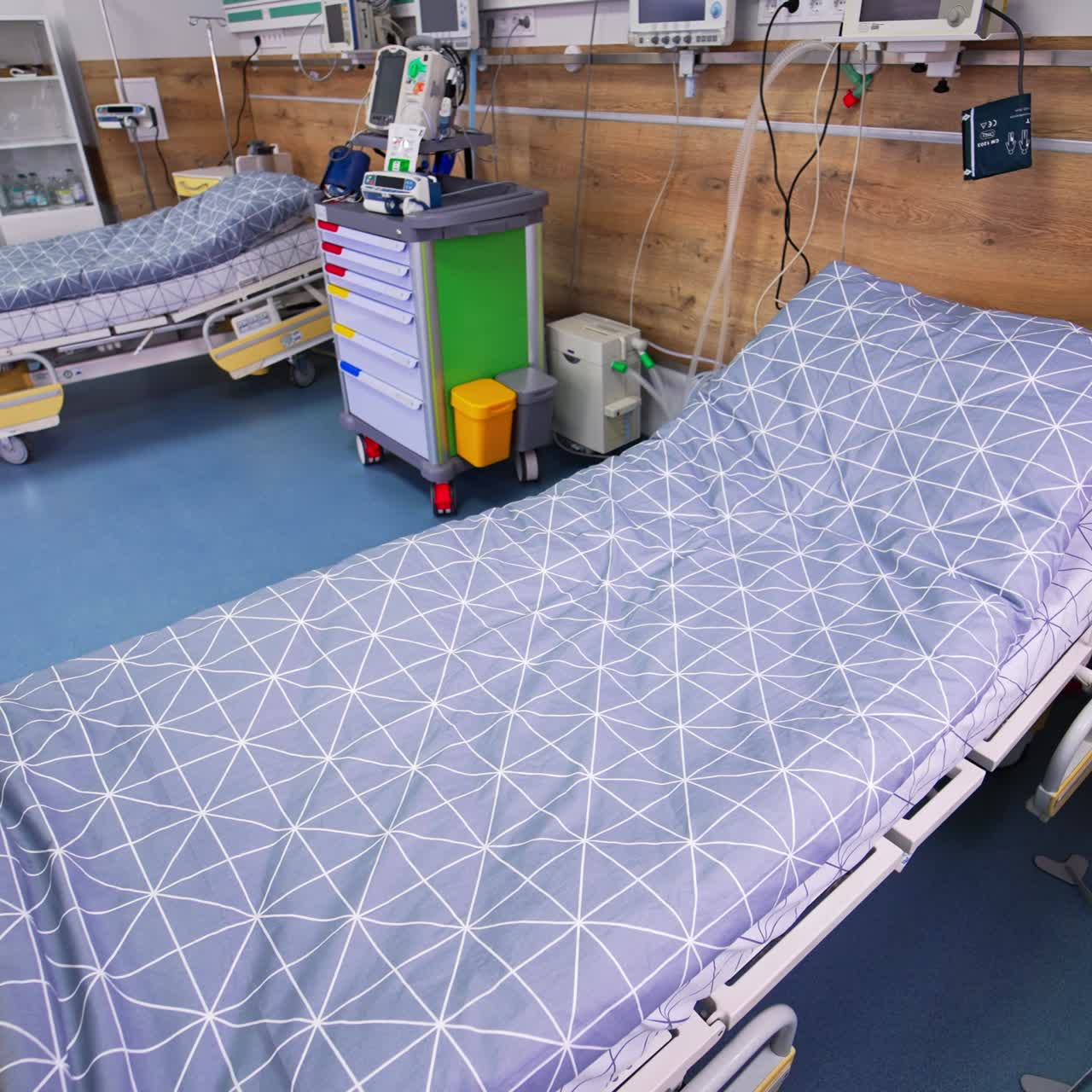 Empty beds in intensive care ward. Medical beds surrounded by innovative devices and tools for reanimation in up-to-date hospital