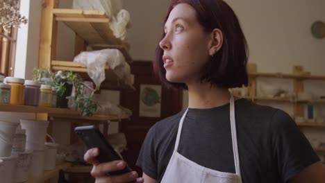 Young-female-potter-working-in-her-studio