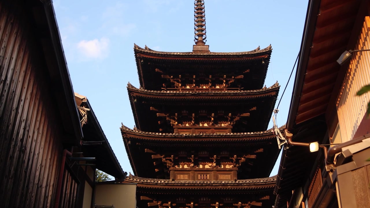 Udsigt fra gadeplan af Yasaka-pagoden ved Hokan-ji-templet, der rejser sig mellem traditionelle bygninger i Kyotos Higashiyama-distrikt og skaber et klassisk perspektiv gennem den historiske gamle bydel.