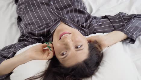 Top-view-of-young-woman-just-woke-up-and-lying-on-the-bed-and-dreaming,stable