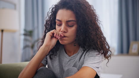 woman sitting on sofa looking pensive