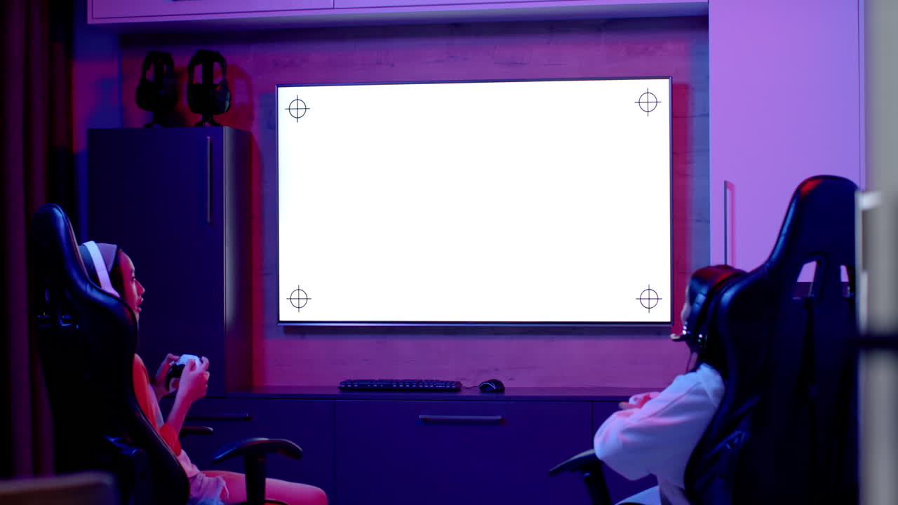 Playing video games, two teenage girls hanging out in gaming chairs, copy space