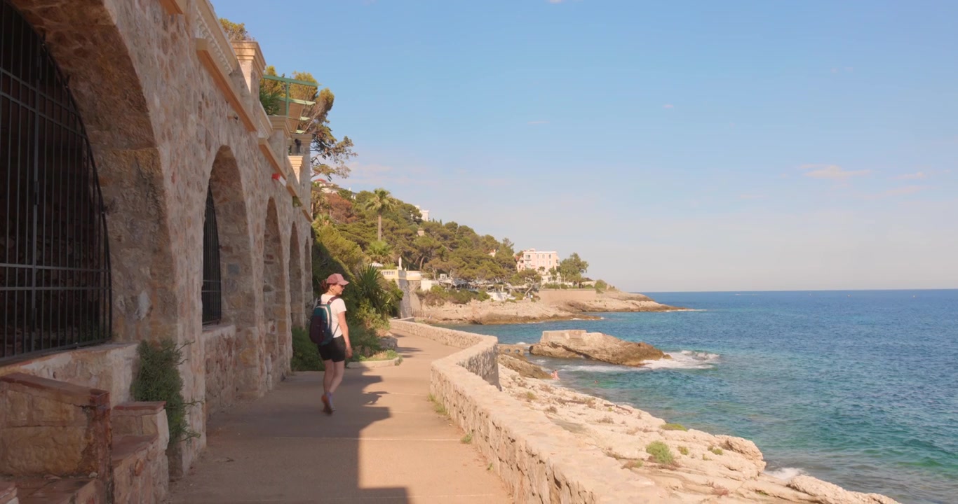 Donna che si gode il famoso sentiero costiero di Cap d'Ail, ambiente marittimo della Costa Azzurra, vicino allo scenografico Mar Mediterraneo, nel Sud della Francia