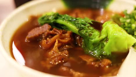 delicious noodle soup with meat and greens