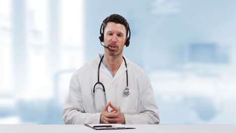 Video-of-caucasian-male-doctor-on-video-consultation-wearing-phone-headset-with-stethoscope