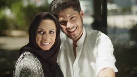 happy muslim couple eating outside, sharing lunch.