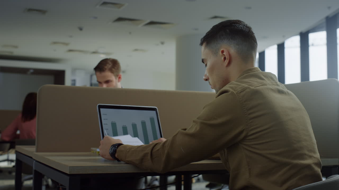 hombre de negocios usando una computadora portátil en un espacio abierto. trabajador navegando por internet en la computadora