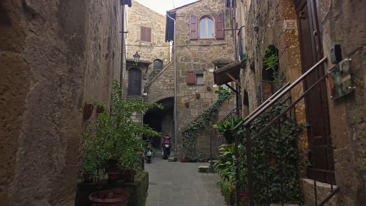이탈리아 토스카니 지방 의 피티글리아노 마을 에서 고대 건축물 들 이 있는 거리 를  ⁇ 고 있다