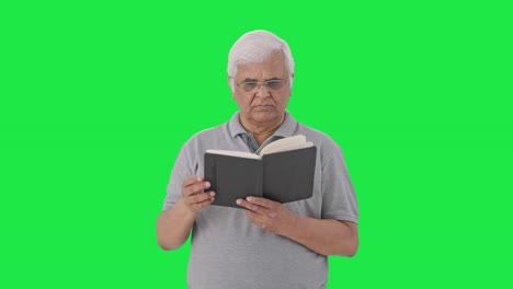 confused indian old man reading a book green screen
