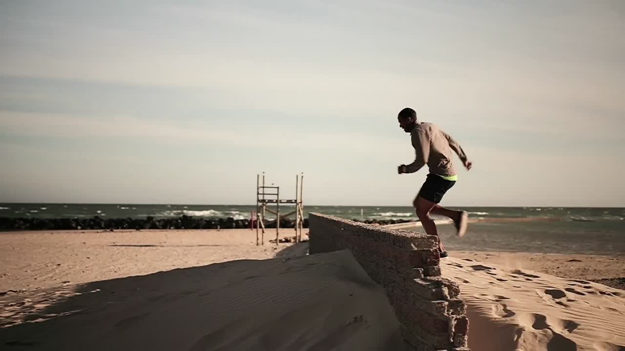 Uomo che corre e salta sulla spiaggia