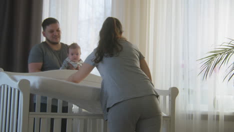 parents with baby in a crib