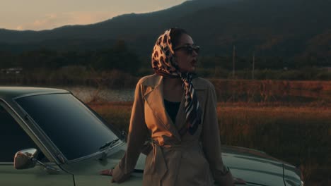 vintage fashion portrait by a classic car at sunset