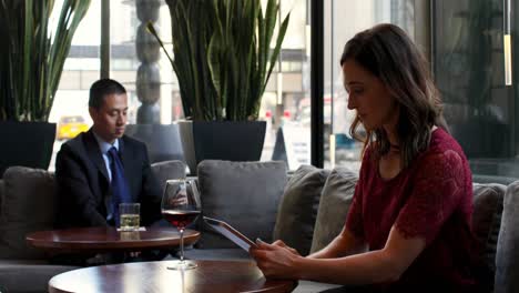 Vista-Lateral-De-Una-Hermosa-Mujer-De-Negocios-Caucásica-Trabajando-En-Una-Tableta-Digital-En-El-Moderno-Hotel-4k