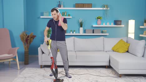hombre feliz bailando y haciendo movimientos divertidos mientras limpia su casa.