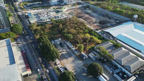 aerial drone shot of cargo trucks parked by large warehouse and construction site in alabang city, muntinlupa, philippines