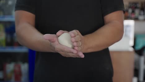 A-skilled-chef-gently-rolls-pizza-dough-in-his-hands