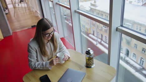 una mujer disfrutando de una copa en un café.