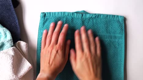 close up of hands folding laundry