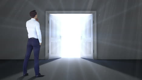 businessman watching door open to light