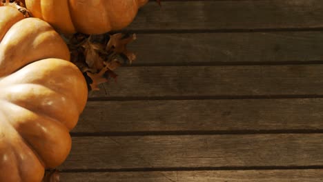 Halloween-pumpkin-with-maple-leaf-on-a-wooden-table-4k