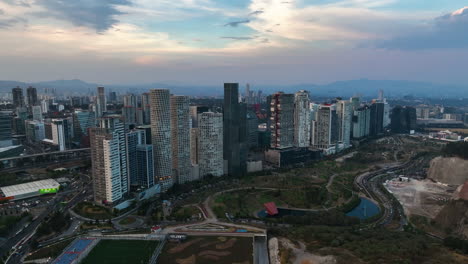 Aerial-view-of-a-row-of-Highrise-in-front-of-the-La-Mexicana-Park,-dusk-in-Santa-Fe,-Mexico